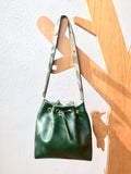 Green leather bucket bag with chevron lining