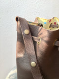 Brown bucket bag with yellow floral lining